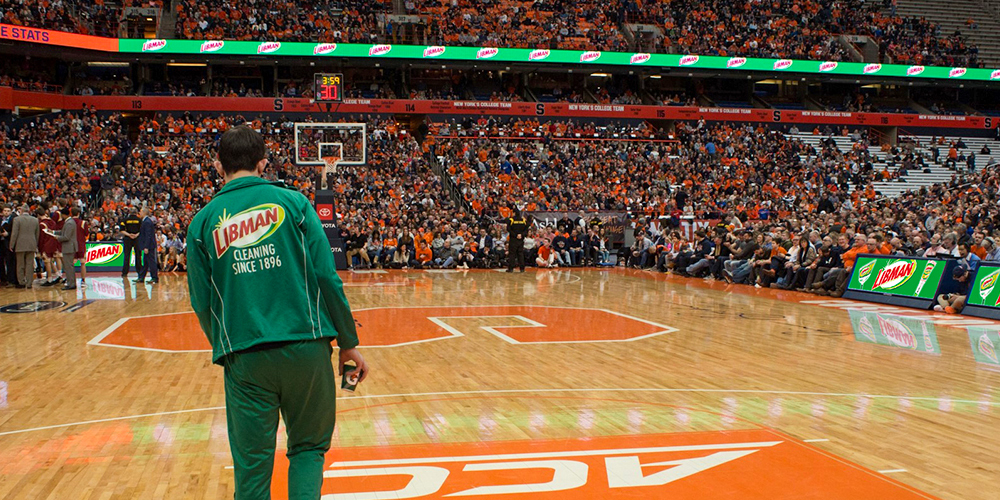 Person in green track suit at a basketball court