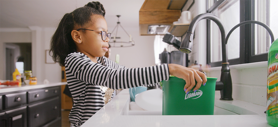 Girl using Rinse 'n Wring in sink