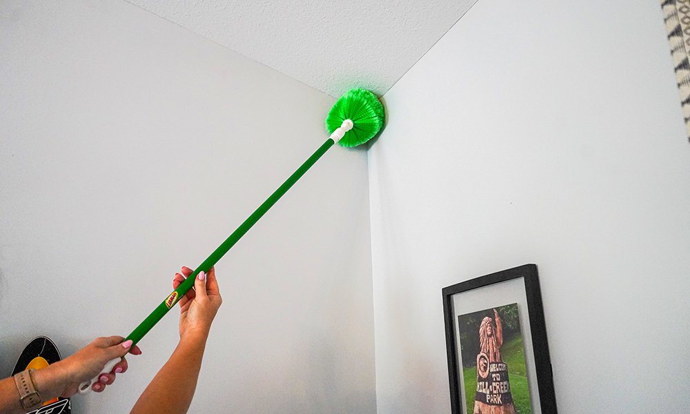 Person dusting ceiling with swivel duster