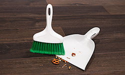 Dustpan and whisk broom on wood floor