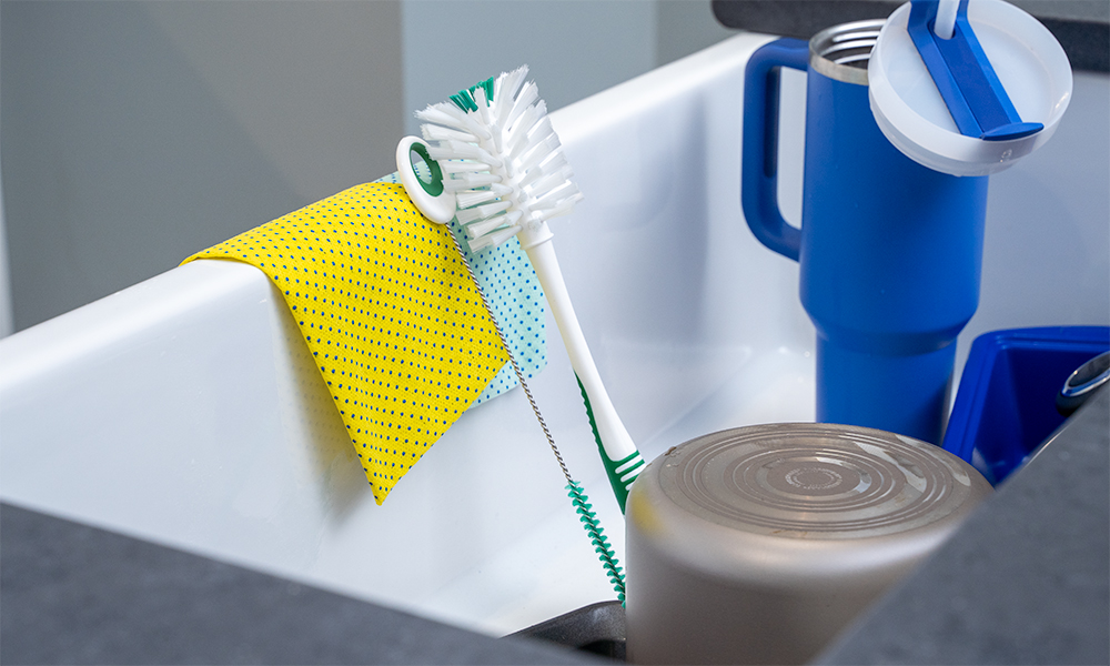 Bottle brush and straw cleaner sitting in a kitchen sink