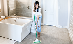 Woman cleans her bathroom floor with the Nitty Gritty Roller Mop