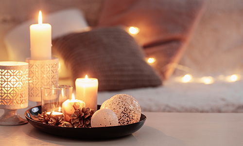 Plate of pinecones, candles, and other decorations on a coffee table