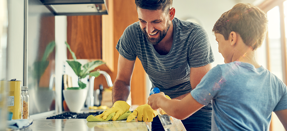 Parent and child cleaning countertop together