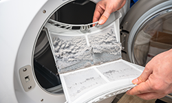 Person removing lint tray from dryer