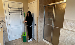 Woman using Rinse 'n Wring mop in her bathroom