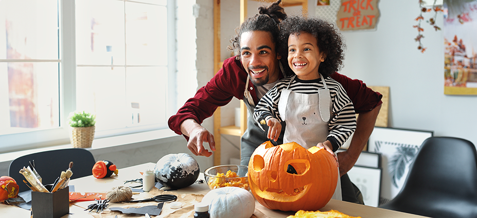 Father and child carving pumpkin