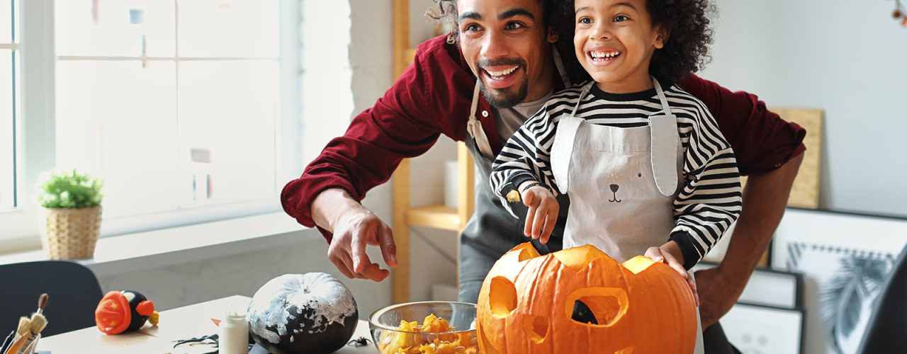 Father and child carving a pumpkin