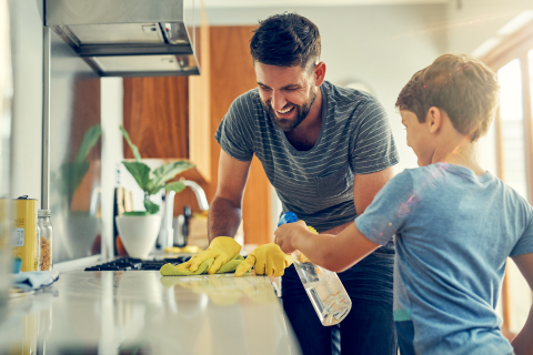 Person and child cleaning countertop together